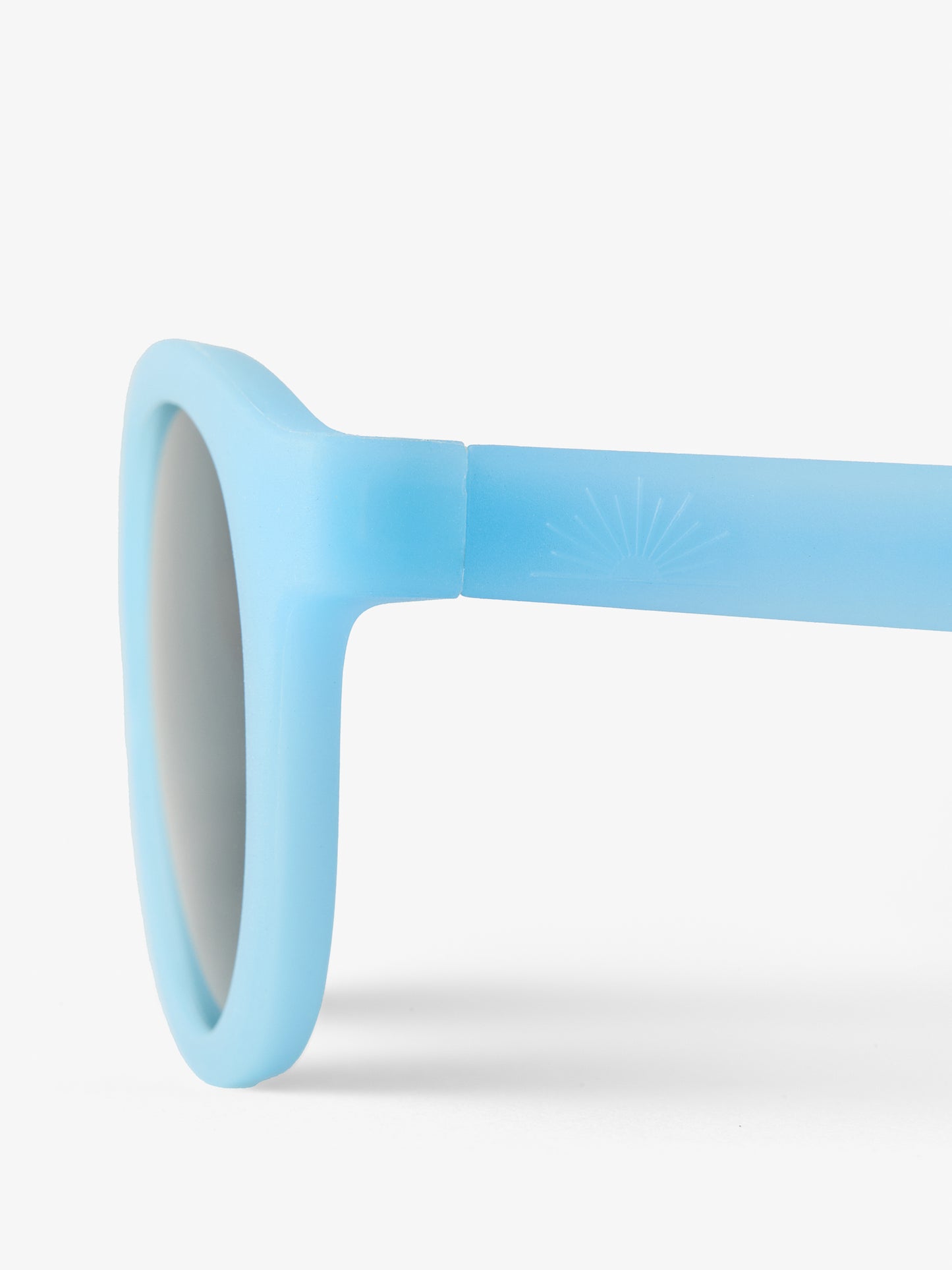 Close up of the side of a pair of blue baby sunglasses with half sun petit peepers logo